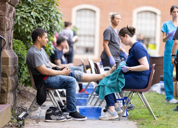 School of Health Science student provides foot care to client at the IPE Health Clinic